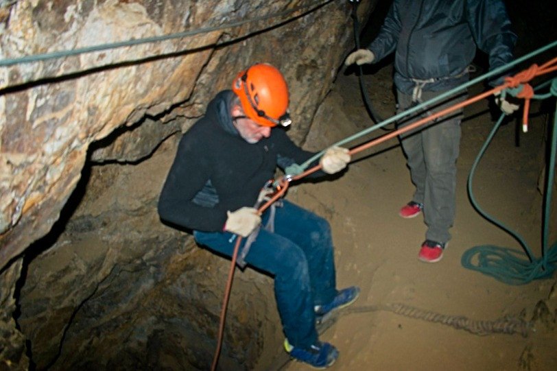 Joven haciendo trekking minero con rappel, dentro de la mina